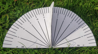 A paper sundial lying on the grass