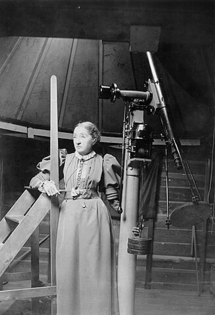 A photograph of Elizabeth Brown with her Wray refractor telescope. 