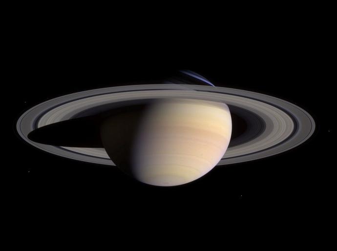 Image of Saturn with its prominent ring system visible, casting a shadow on the planet's upper hemisphere.